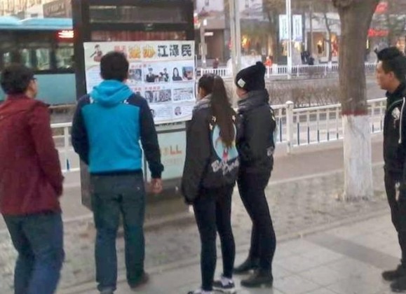 People read a poster with firsthand accounts from Falun Gong practitioners.