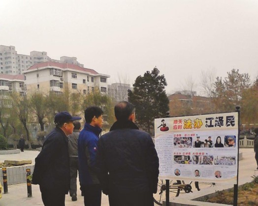 Passersby look at a poster in Shijiazhuang City, Hebei Province.