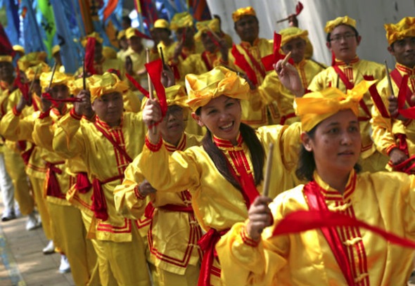 Falun Gong practitioners play instruments during a protest in front of the Chinese Embassy in Jakarta, Indonesia in this file photo from Aug 14, 2010. An elderly falun gong practitioner says she was subject to harassment while doing her weekly meditation on a street opposite the Chinese embassy on Ratchadapisek Road in Bangkok on Friday morning. (AP Photo/Achmad Ibrahim)