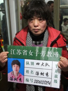 Tang Shuxiu, 51, was sent to a re-education through labor camp in 2011 after she complained that her local government work unit failed to give her an apartment. She holds a mock-up of her labor camp ID card in order to publicize the abuses of labor camps and push for change. ) Frank Langfitt/NPR)
