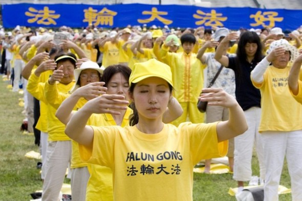 Hundreds of Falun Gong practitioners practice exercises on the grand lawn in front of the U.S. Capitol on July 12 prior to a rally highlighting the persecution of Falun Gong in China. (Ma Youzhi/The Epoch Times)