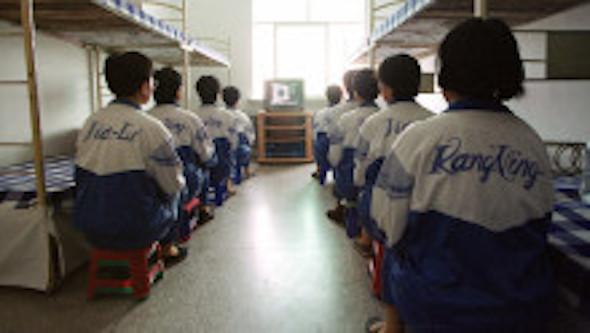 Falun Gong practitioners watch a video at the Masanjia re-education through labor camp in northeast China's Liaoning province on May 22, 2001.