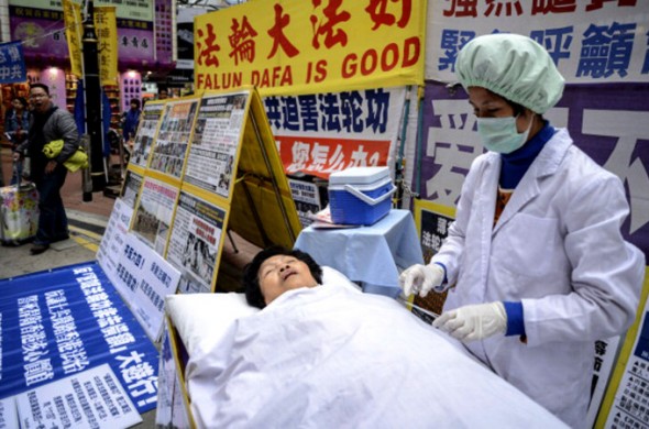 Falun Gong members perform a mock forced organ removal performance in Hong Kong January 12, 2013. Photo: Getty Images