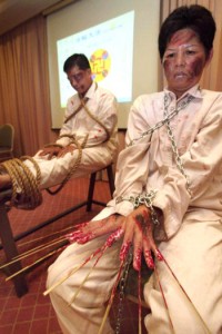 Falun Gong supporters put on a performance of torture methods used by the Chinese government during a press conference in Kuala Lumpur, Malaysia December, 2004.  Photo: Getty Images