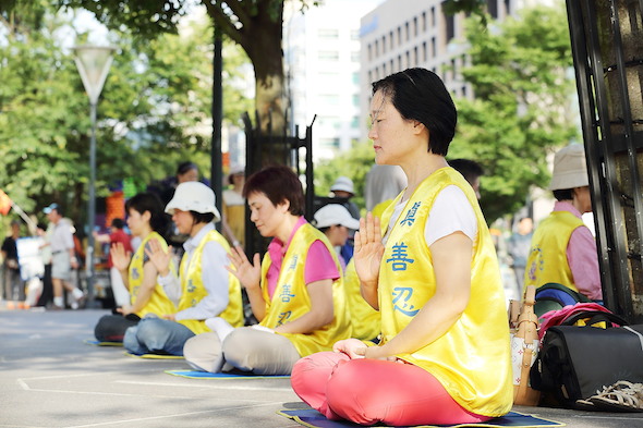 Falun Gong practitioners meditate outside the Taipei 101 building in Taiwan’s capital in October 2013. The group has been targeted by roughneck pro-Chinese Communist Party activists in the last few years. (Ke-Ren/Epoch Times)
