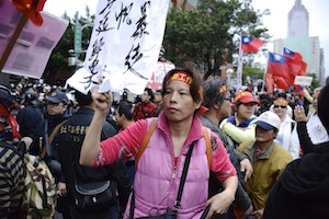 Zhang Xiuye, a proactive member of the Concentric Patriotism Association, and no stranger to rough tactics, holds a banner near the Executive Yuan in Taipei on April 1, 2014, calling for the arrest of student activists. (J. Michael Cole)