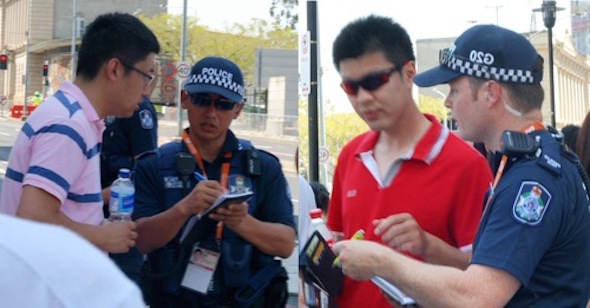 The police officers in Brisbane ask the students organized by the Chinese Consulate to show their ID and take down their information to make sure that they would not make trouble for Falun Gong protestors.
