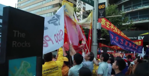 This screenshot shows Chinese government supporters attempting to push out protesters and place red flags over their banners during Chinese leader Xi Jinping’s visit to Sydney on Nov 18. (Screenshot from S.G. Hughes/YouTube)