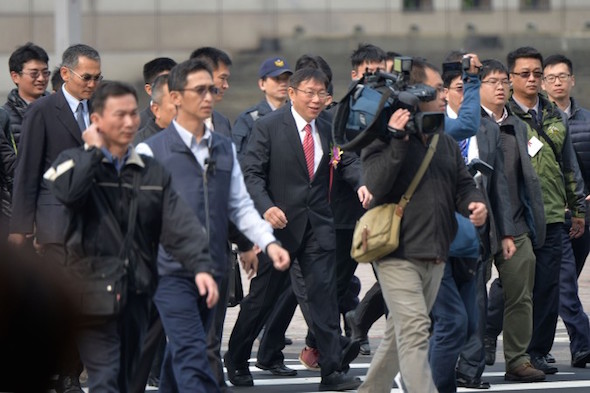 Taipei mayor Dr. Ko Wen-je (center, red tie) surrounded by reporters on his first day in office on Dec. 25, 2014. (CNA News)