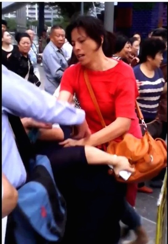 When Ms. Tsai (in purple) was touring Taipei 101 with her child on October 27, 2014, Zhang (in red) and another association member, Xiao Qin, struck and injured her.