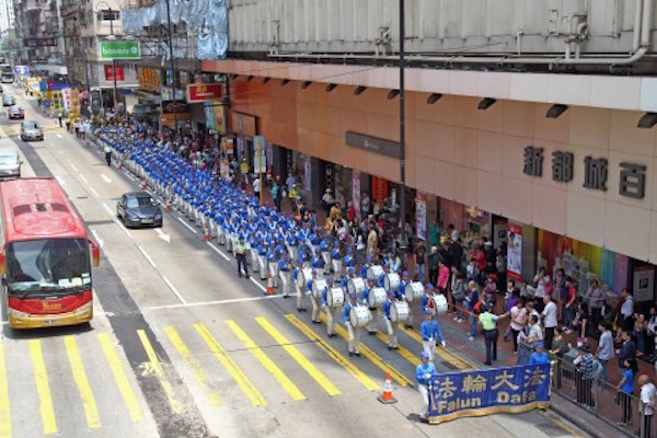 About 800 Falun Gong practitioners from Hong Kong and neighboring countries participate in a parade in Hong Kong Island on April 26, 2015, to commemorate the 16th anniversary of the peaceful protest of Falun Gong practitioners in Beijing on April 25, 1999, to defend their legal right to religious freedom and call for the release of fellow practitioners arrested for their faith. Tianguo Marching Band is leading the parade marching through the city. (Epoch Times)
