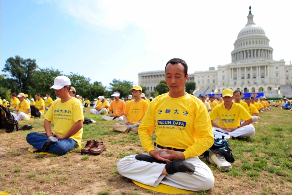 Falun Gong practitioners meditate on Capitol Hill on July 12, 2014, calling for an end to the persecution in China. (Edward Dye/Epoch Times)