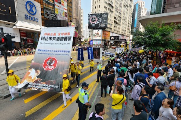 About 800 Falun Gong practitioners from Hong Kong and neighboring countries participate in a parade in Hong Kong Island on April 26, 2015, to commemorate the 16th anniversary of the peaceful protest of Falun Gong practitioners in Beijing on April 25, 1999, to defend their legal right to religious freedom and call for the release of fellow practitioners arrested for their faith. In the procession, practitioners carry large banner of live organ harvesting in China and call to stop this inhuman practice. (Epoch Times)